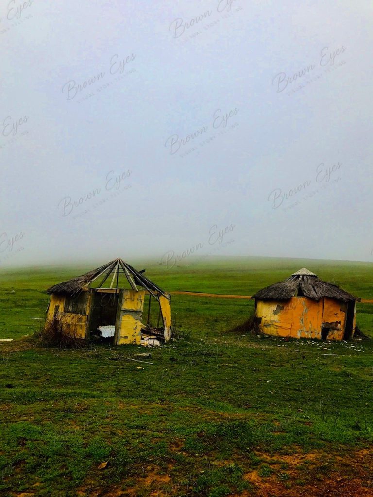Mist drifting over a cluster of weathered huts